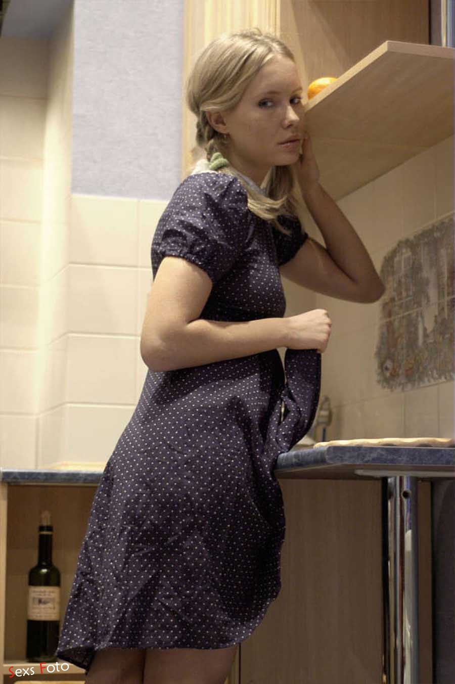 Блондинка в платье без трусов позирует на кухне (9 фото)